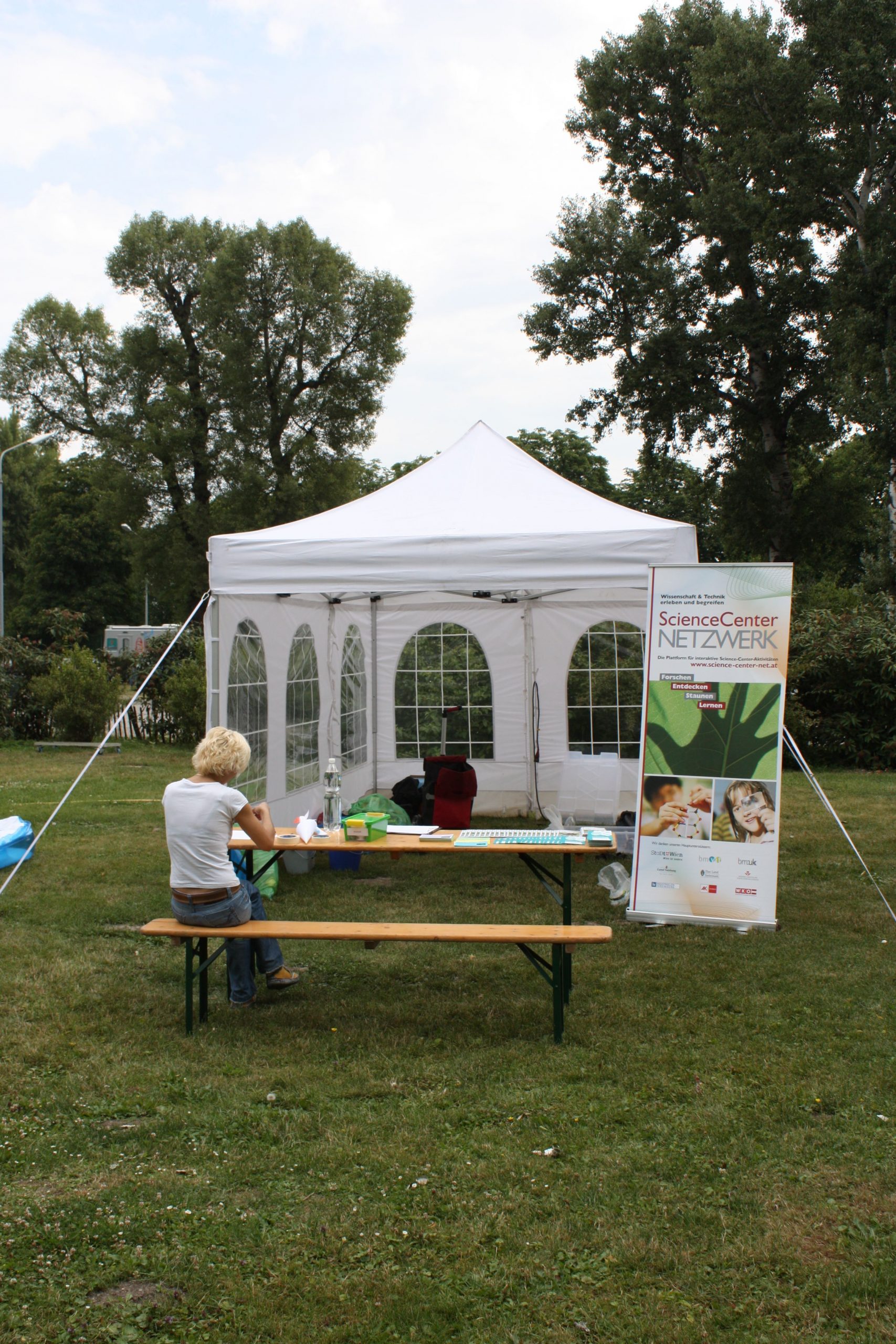 Zelt und Tisch mit Experimentiermaterialien im Park